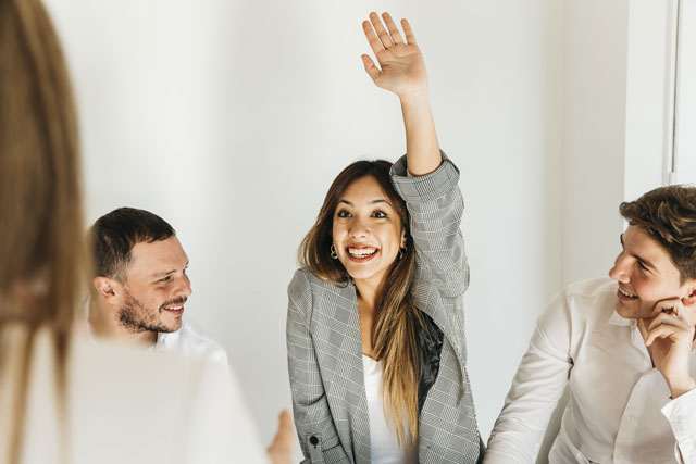 Enthusiastic young woman with raised hand